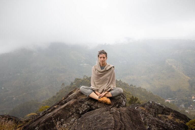 Woman meditating peacefully in a calm mountain landscape, illustrating how stress recovery supports healthy aging