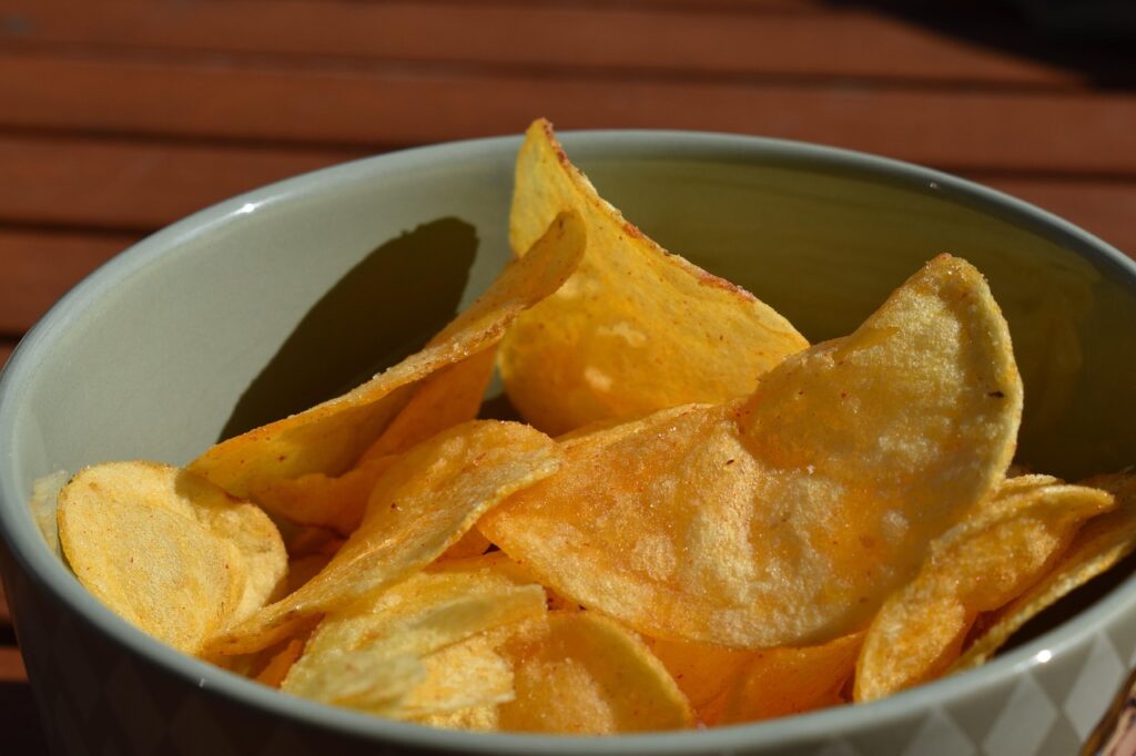 A bowl of salty potato chips, a common type of ultra-processed food, illustrating research on ultra-processed foods and depression symptoms