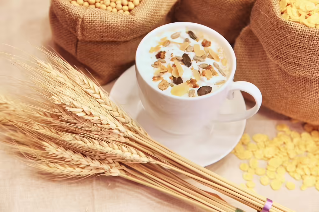 A bowl of muesli or cereal with grains, dried fruits and seeds on a wooden table, representing a healthy high-fiber breakfast option