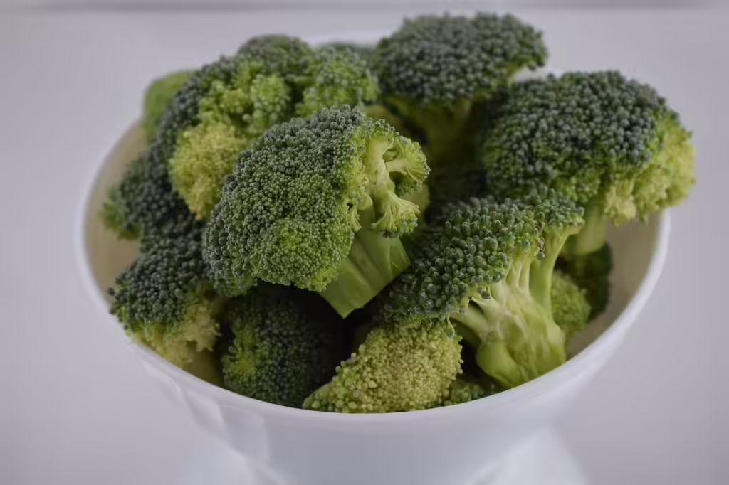 Fresh green broccoli florets arranged in a white bowl, perfect for healthy broccoli salad recipes with nutritious cruciferous vegetables